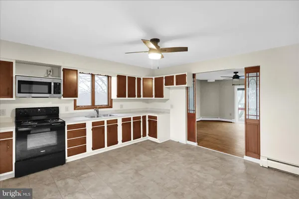 a kitchen with stainless steel appliances granite countertop a stove top oven a sink and a refrigerator