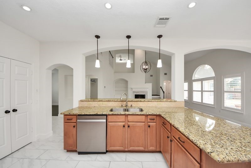 20831 Deauville Drive Spring, TX 77388 - Photo 20 of 42 Lovely tier lighting over the breakfast bar, look how open the kitchen and family room are!
