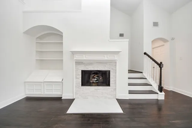 a living room with a fireplace and wooden floor