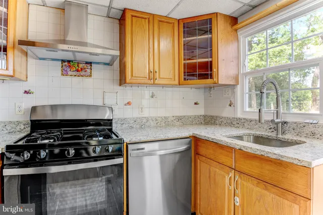 a kitchen with stainless steel appliances granite countertop a sink stove and cabinets