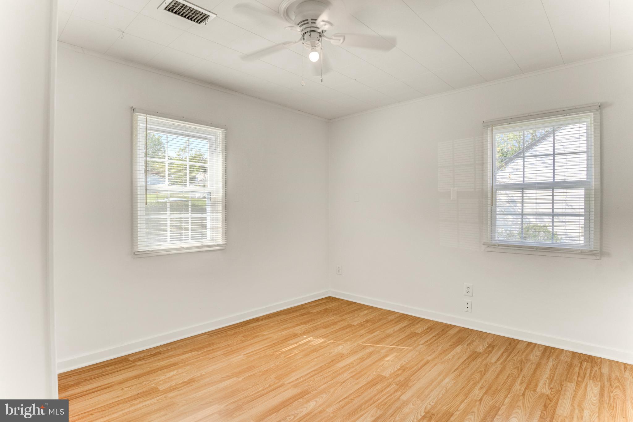 3106 Burgundy Road Alexandria, VA 22303 - Photo 8 of 24 an empty room with wooden floor cabinet and windows