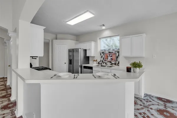 a view of a kitchen with a sink and refrigerator