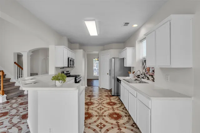 a large white kitchen with a stove and refrigerator