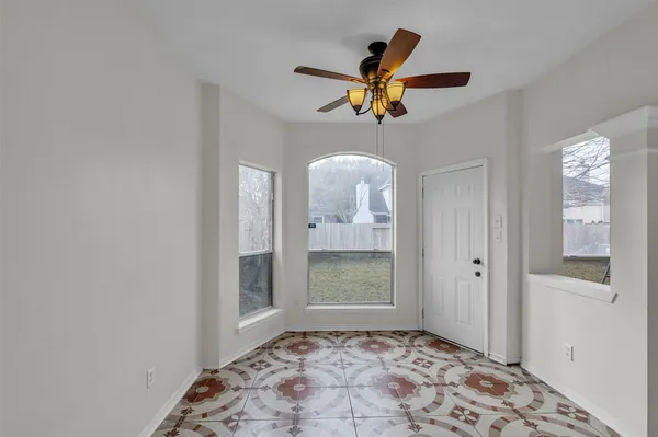 a view of a hallway with a chandelier fan and a bathroom