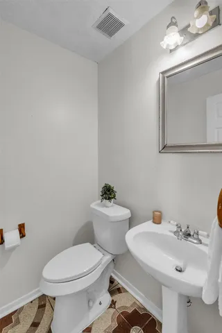 a bathroom with a sink mirror and toilet