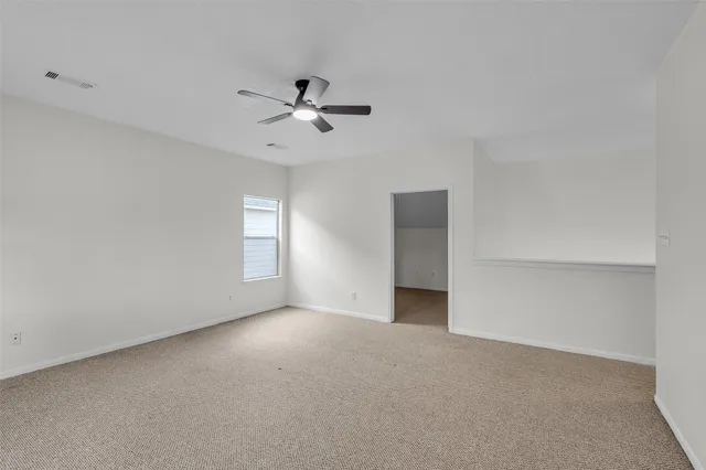 a view of empty room with ceiling fan