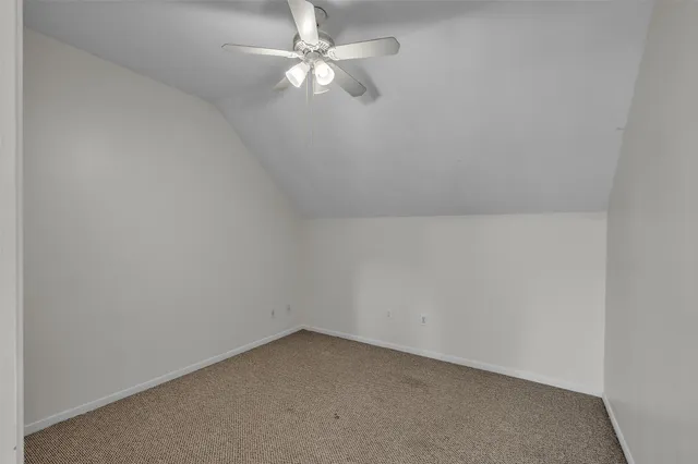 an empty room with a fan & a ceiling fan