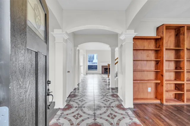 a view of a hallway with wooden floor and a living room