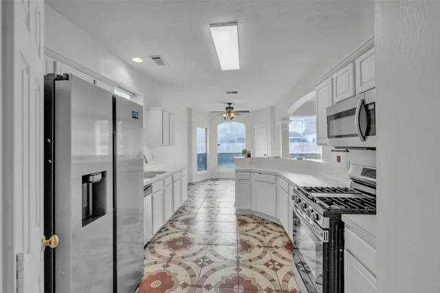 a kitchen with stainless steel appliances a refrigerator sink and stove