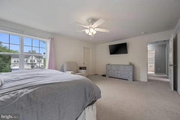 a spacious bedroom with a bed and a tv