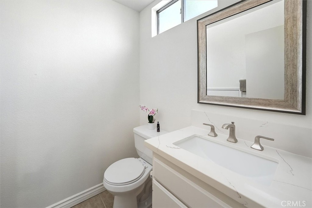 22713 Copper Hill Drive, Unit 42 Saugus, CA 91350 - Photo 19 of 32 a bathroom with a toilet sink and mirror