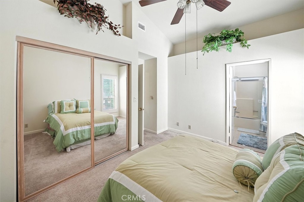 22713 Copper Hill Drive, Unit 42 Saugus, CA 91350 - Photo 26 of 32 a spacious bedroom with a large bed and a chandelier