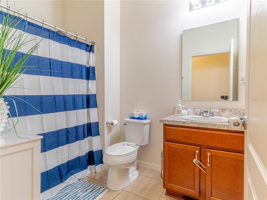 4504 Orchard Grove Road St. Cloud, FL 34772 - Photo 11 of 29 a bathroom with a sink a toilet a shower curtain and a mirror
