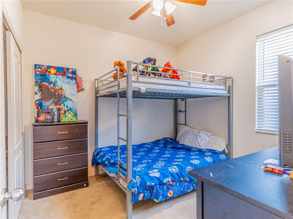 4504 Orchard Grove Road St. Cloud, FL 34772 - Photo 12 of 29 a bedroom with a bed and a chandelier