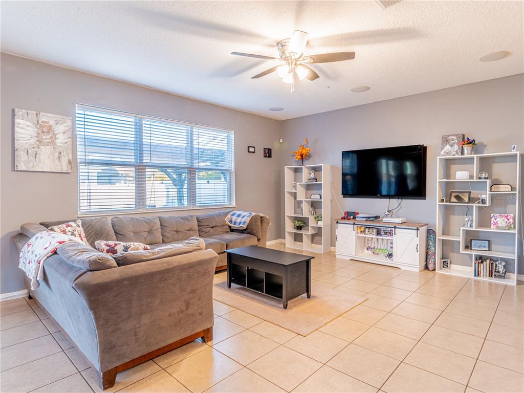 4504 Orchard Grove Road St. Cloud, FL 34772 - Photo 17 of 29 a living room with furniture and a flat screen tv
