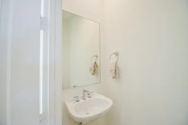 a bedroom with a bed a computer on desk and a dresser next to a window