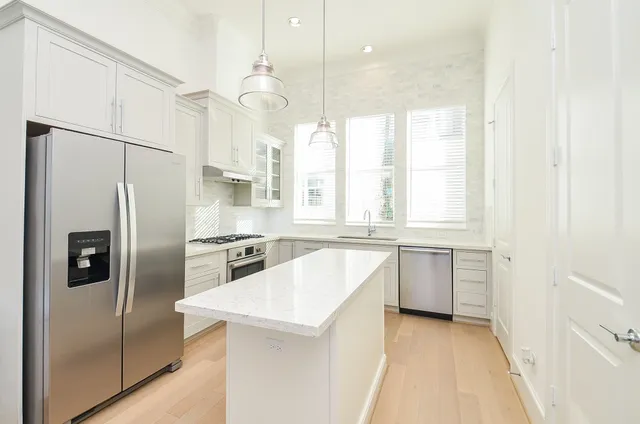 a kitchen with a refrigerator a sink and cabinets
