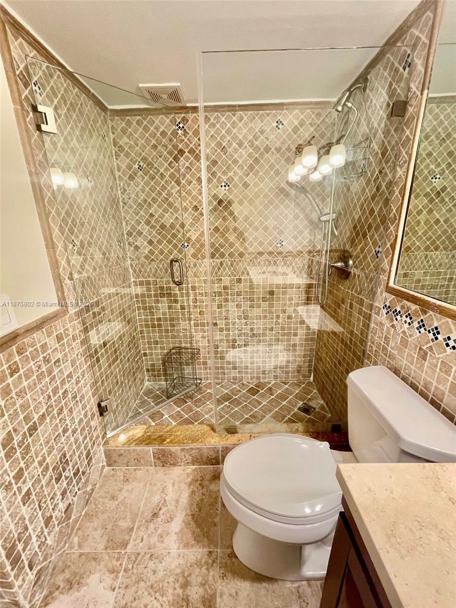 2851 Northeast 183rd Street, Unit 802E Aventura, FL 33160 - Photo 14 of 37 a bathroom with a toilet and shower