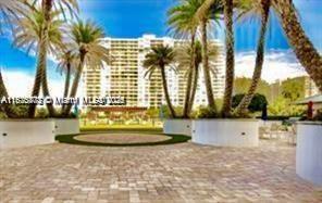 2851 Northeast 183rd Street, Unit 802E Aventura, FL 33160 - Photo 22 of 37 a view of swimming pool with a yard and palm trees
