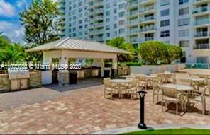 2851 Northeast 183rd Street, Unit 802E Aventura, FL 33160 - Photo 32 of 37 a patio with a table and chairs under an umbrella
