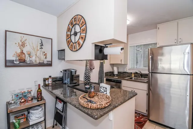 a kitchen with stainless steel appliances granite countertop a refrigerator and a sink