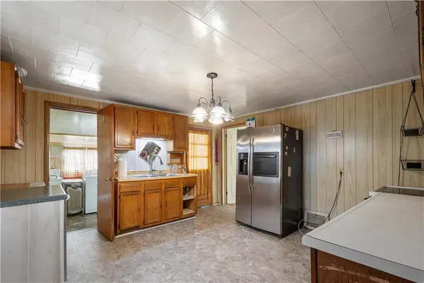 a living room with stainless steel appliances granite countertop furniture and a chandelier