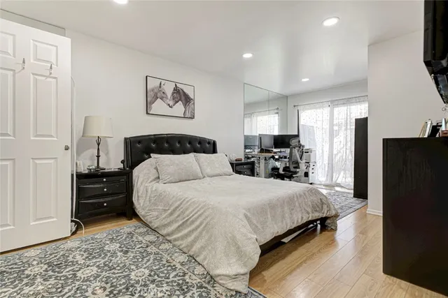 a large bedroom with a bed and a flat screen tv
