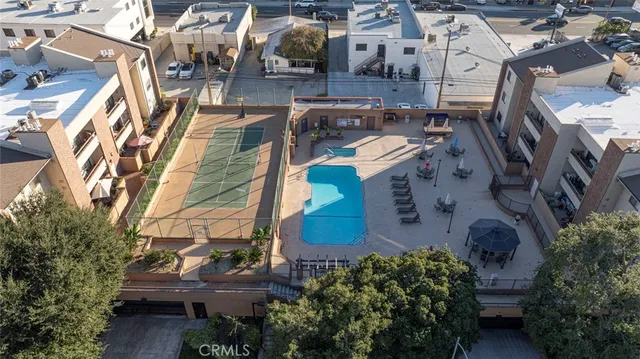 an aerial view of residential houses with outdoor space and parking