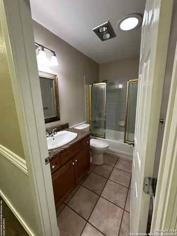 a bathroom with a double vanity sink toilet and mirror