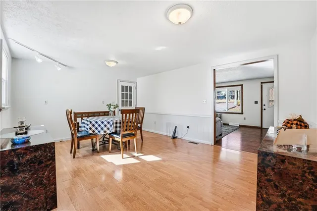 a kitchen with stainless steel appliances granite countertop a stove top oven a refrigerator a sink and dishwasher with wooden floor