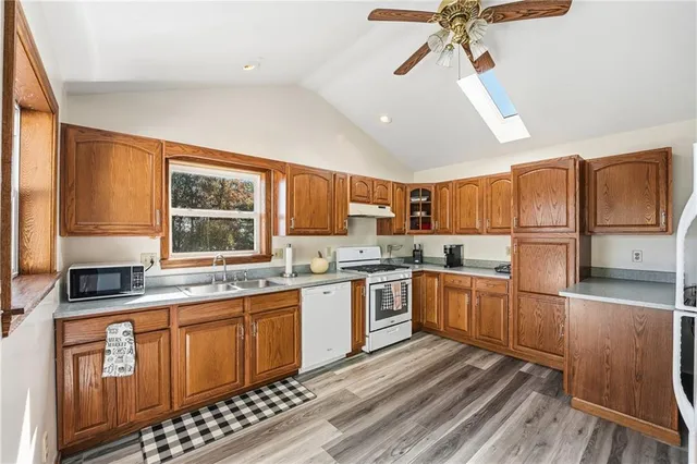 a kitchen with a refrigerator a stove a sink dishwasher and wooden cabinets