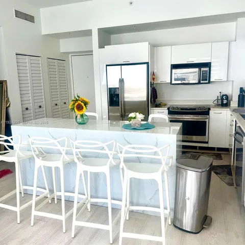 a kitchen with granite countertop a stove a sink cabinetry and a dining table