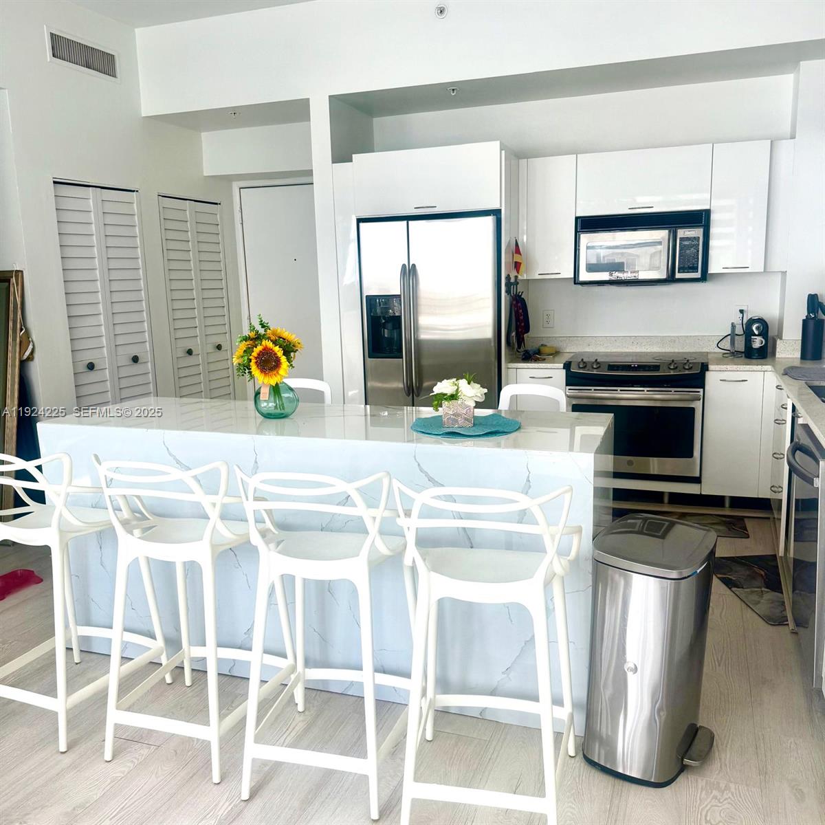133 Northeast 2nd Avenue, Unit 208 Miami, FL 33132 - Photo 1 of 22 a kitchen with granite countertop a stove a sink cabinetry and a dining table