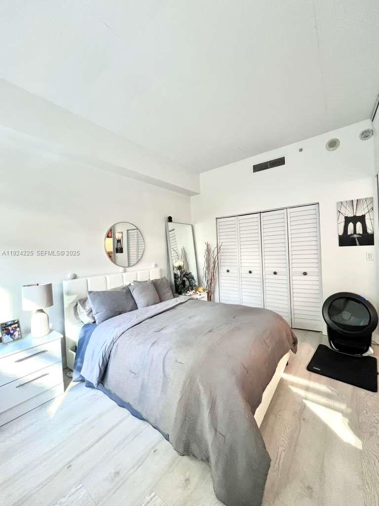 133 Northeast 2nd Avenue, Unit 208 Miami, FL 33132 - Photo 12 of 22 a bedroom with a bed and a cabinets