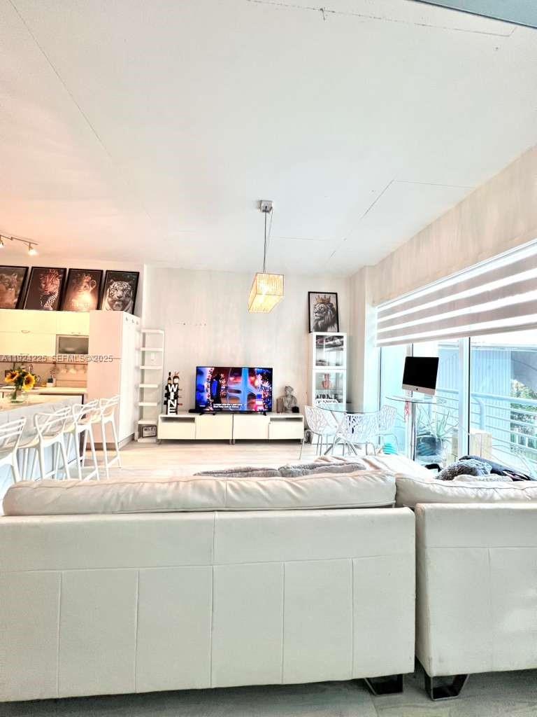 133 Northeast 2nd Avenue, Unit 208 Miami, FL 33132 - Photo 14 of 22 a living room with furniture and a chandelier