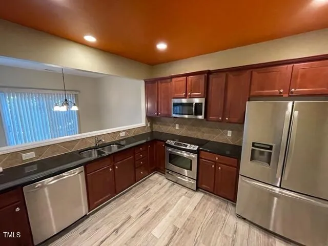 a kitchen with granite countertop stainless steel appliances and wooden cabinets