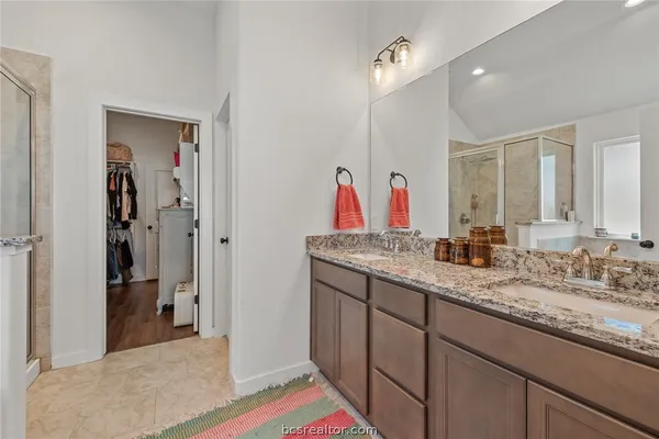 a en suite bathroom with a granite countertop sink and a mirror