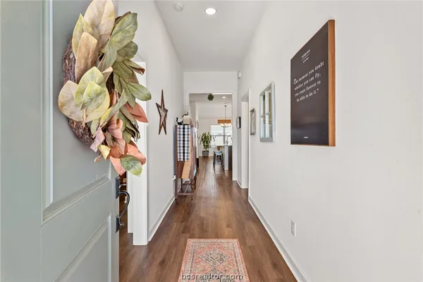 a view of a hallway with wooden floor and entryway