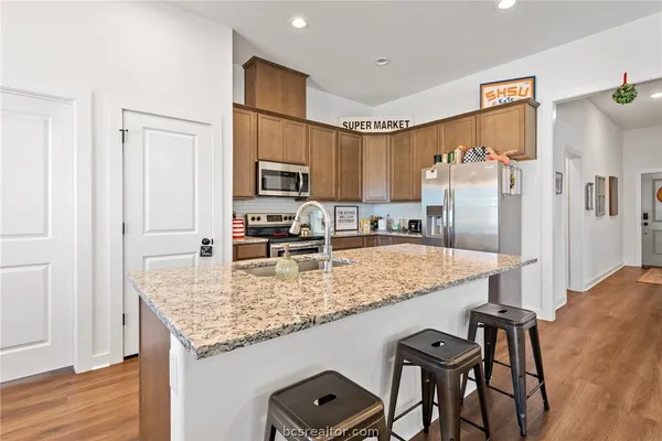 a kitchen with kitchen island a counter top space appliances and cabinets