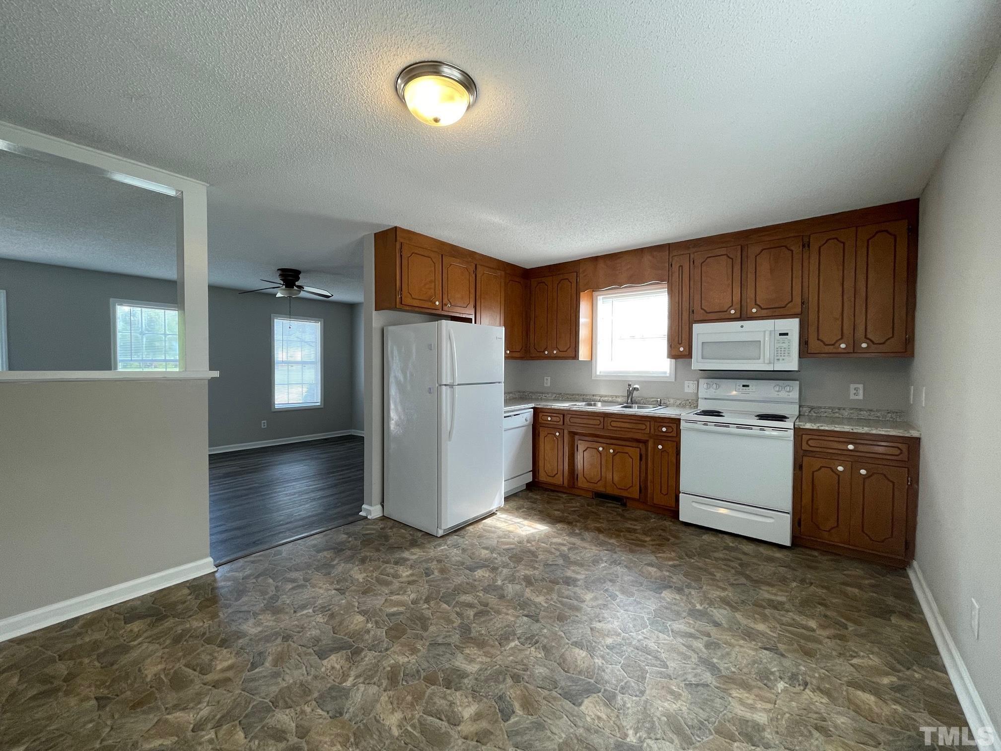 231 Smith Drive Angier, NC 27501 - Photo 4 of 19 a kitchen with granite countertop a refrigerator and cabinets
