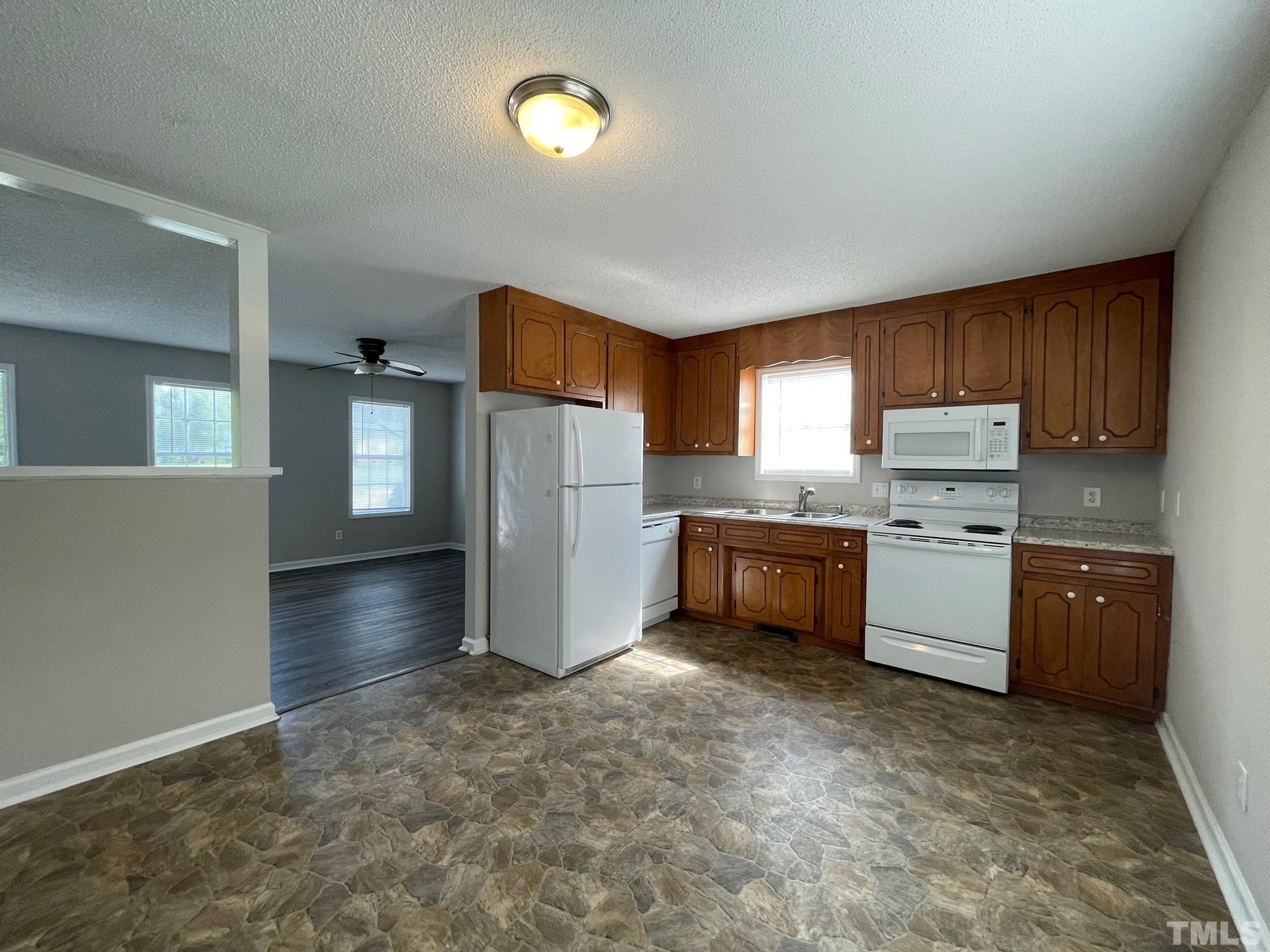 231 Smith Drive Angier, NC 27501 - Photo 5 of 19 a kitchen with granite countertop a refrigerator and a stove