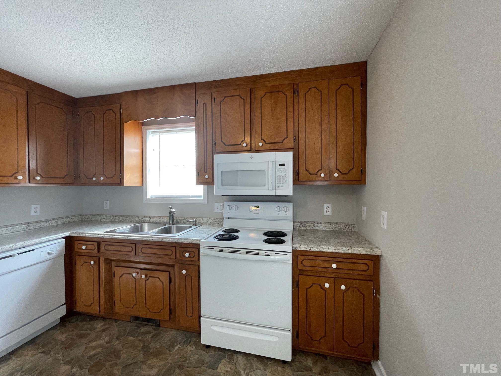 231 Smith Drive Angier, NC 27501 - Photo 6 of 19 a kitchen with a sink a stove and cabinets