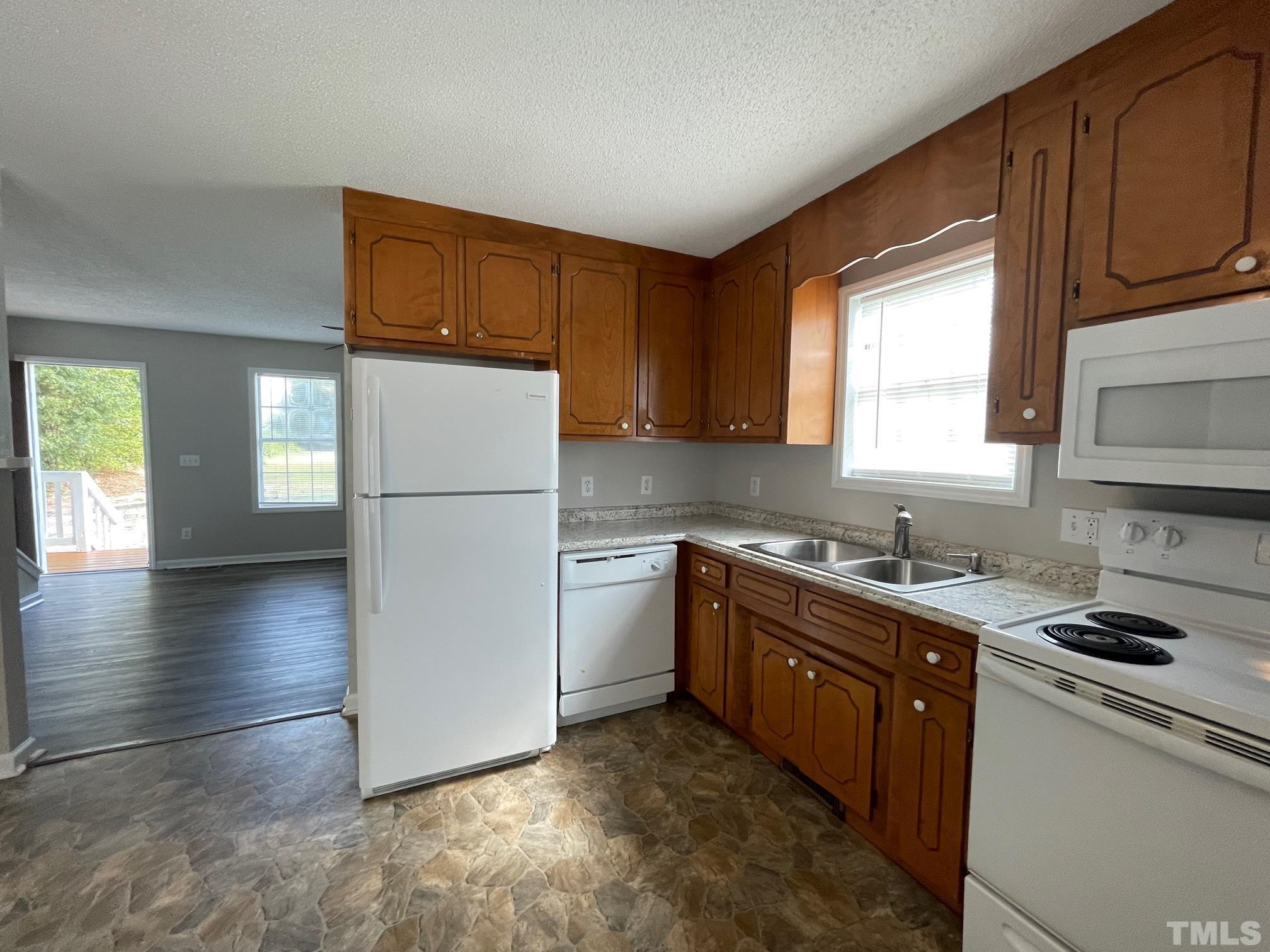 231 Smith Drive Angier, NC 27501 - Photo 7 of 19 a kitchen with a refrigerator stove top oven and sink