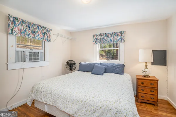 a bedroom with a bed and a flat tv screen on the dresser