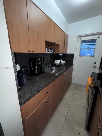 a kitchen with granite countertop a sink a stove and a microwave