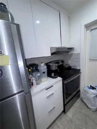 a kitchen with a refrigerator and a stove