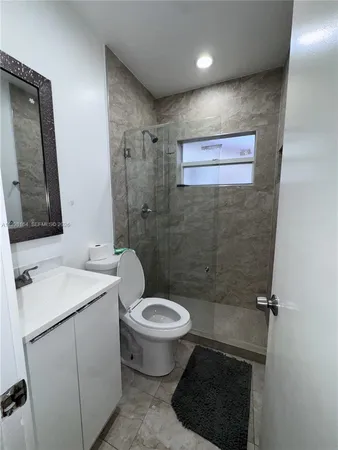a bathroom with a toilet a sink and mirror