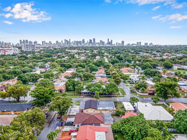 an aerial view of a city with lots of residential buildings ocean and mountain view in back