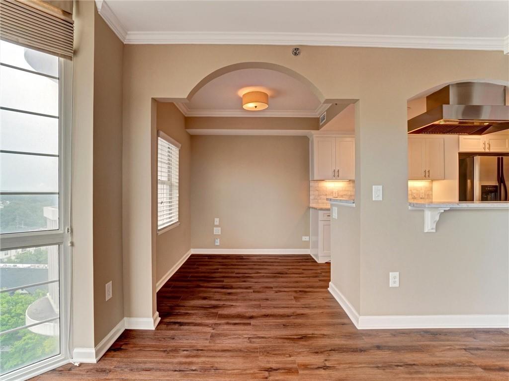 3435 Kingsboro Road Northeast, Unit 1601 Atlanta, GA 30326 - Photo 10 of 54 a view of a hallway with wooden floor and a fireplace