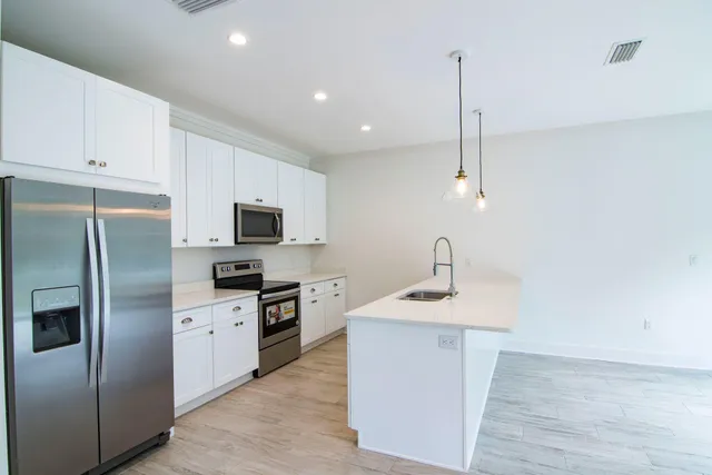 a view of a kitchen with a sink and a chandelier